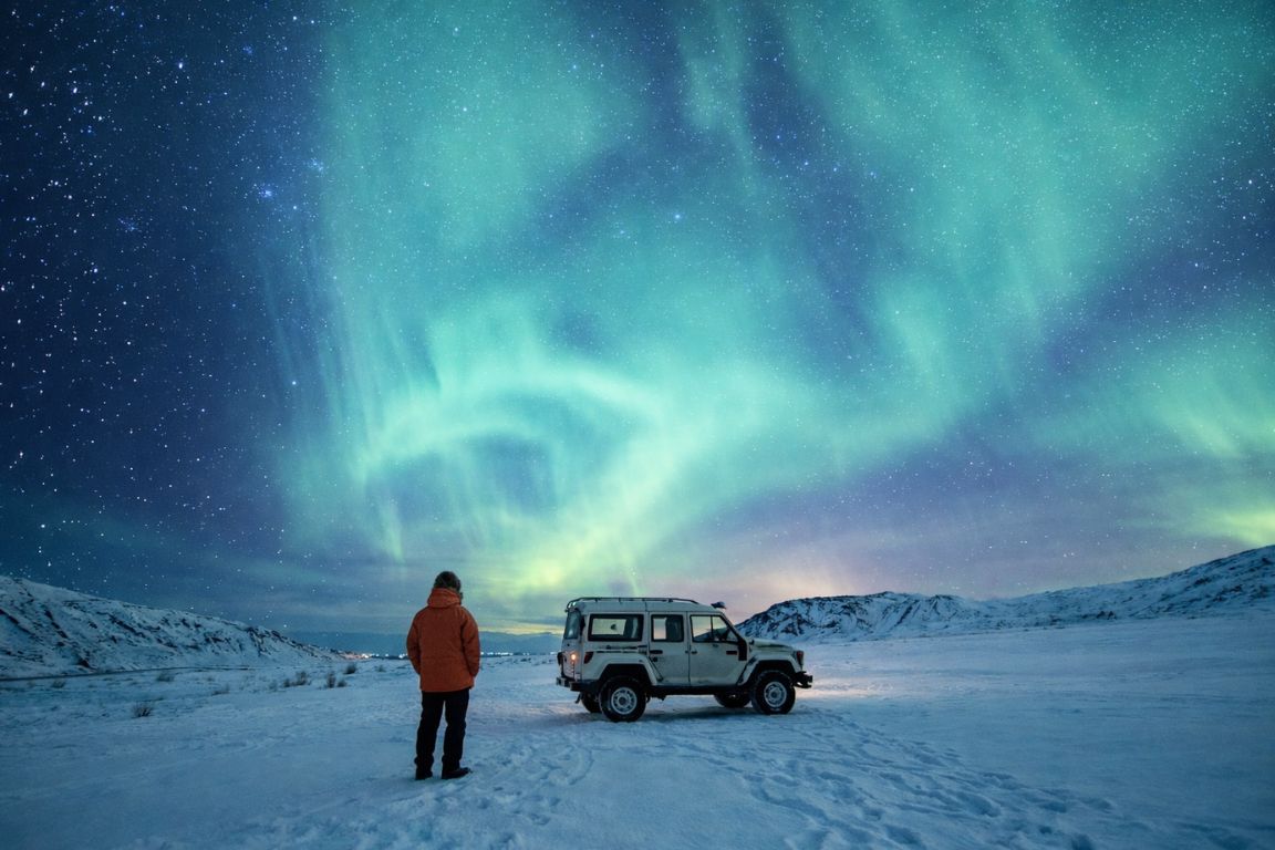 Aurora forecast location in northern Norway photographed during a Tromso Norway Tours guided aurora safari, with bright Northern Lights illuminating the winter landscape